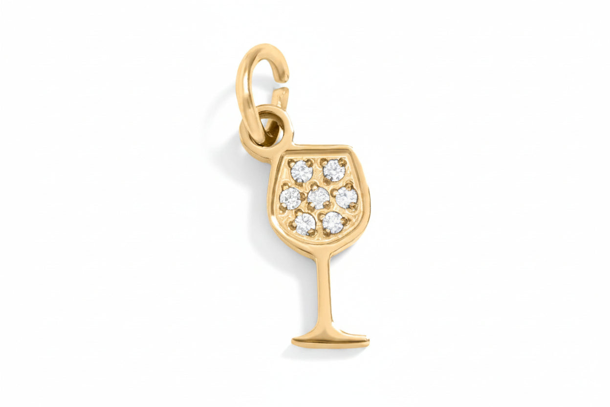 Gold wine glass charm with embedded stones on a white background